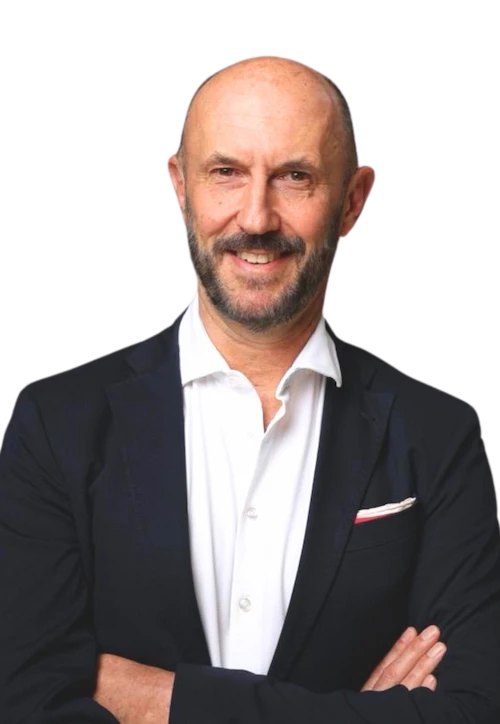 Porträt von Prof. Dr. med. Marc Bloching, freundlich lächelnd, mit verschränkten Armen im dunklen Sakko und weißem Hemd, vor transparentem Hintergrund. Das Bild ist auf der Teamsektion verankert